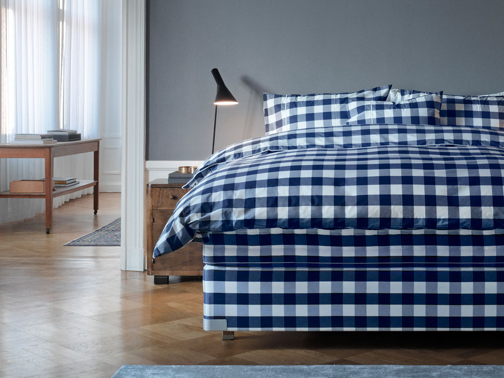 Kategoriebild: Bett mit mit blau-karrierter Betwäsche